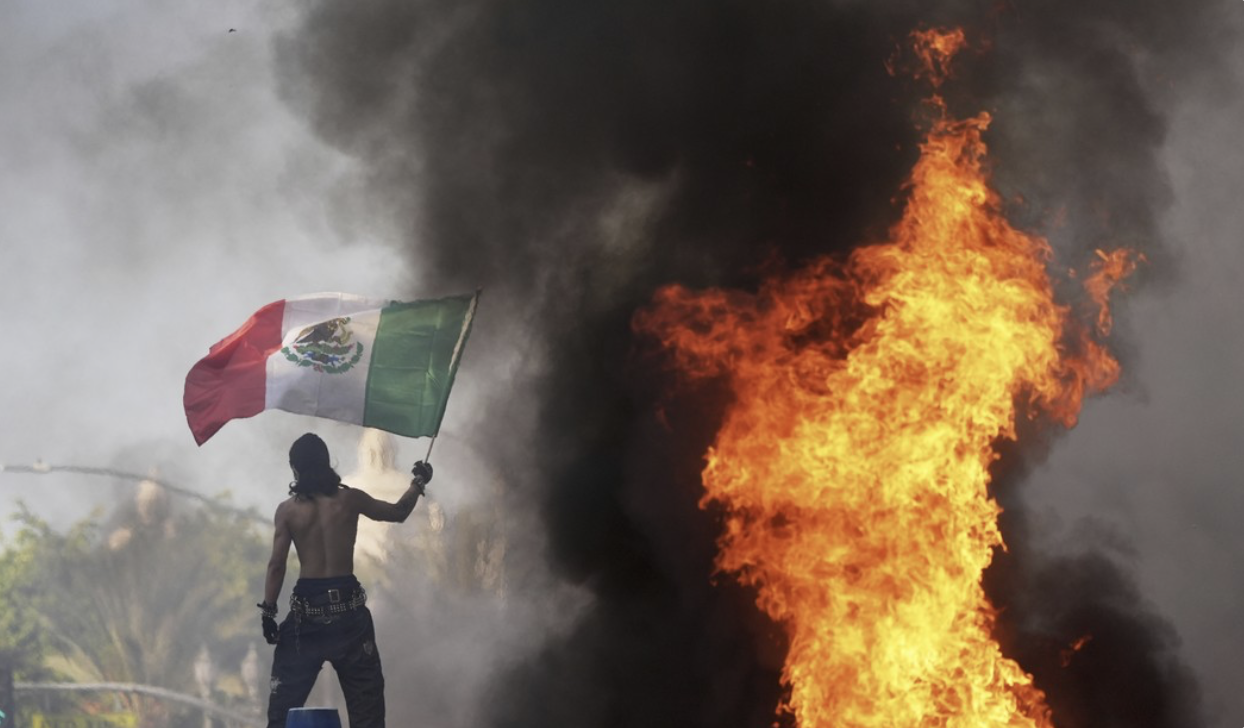 Immigration protester waves mexican flag fire