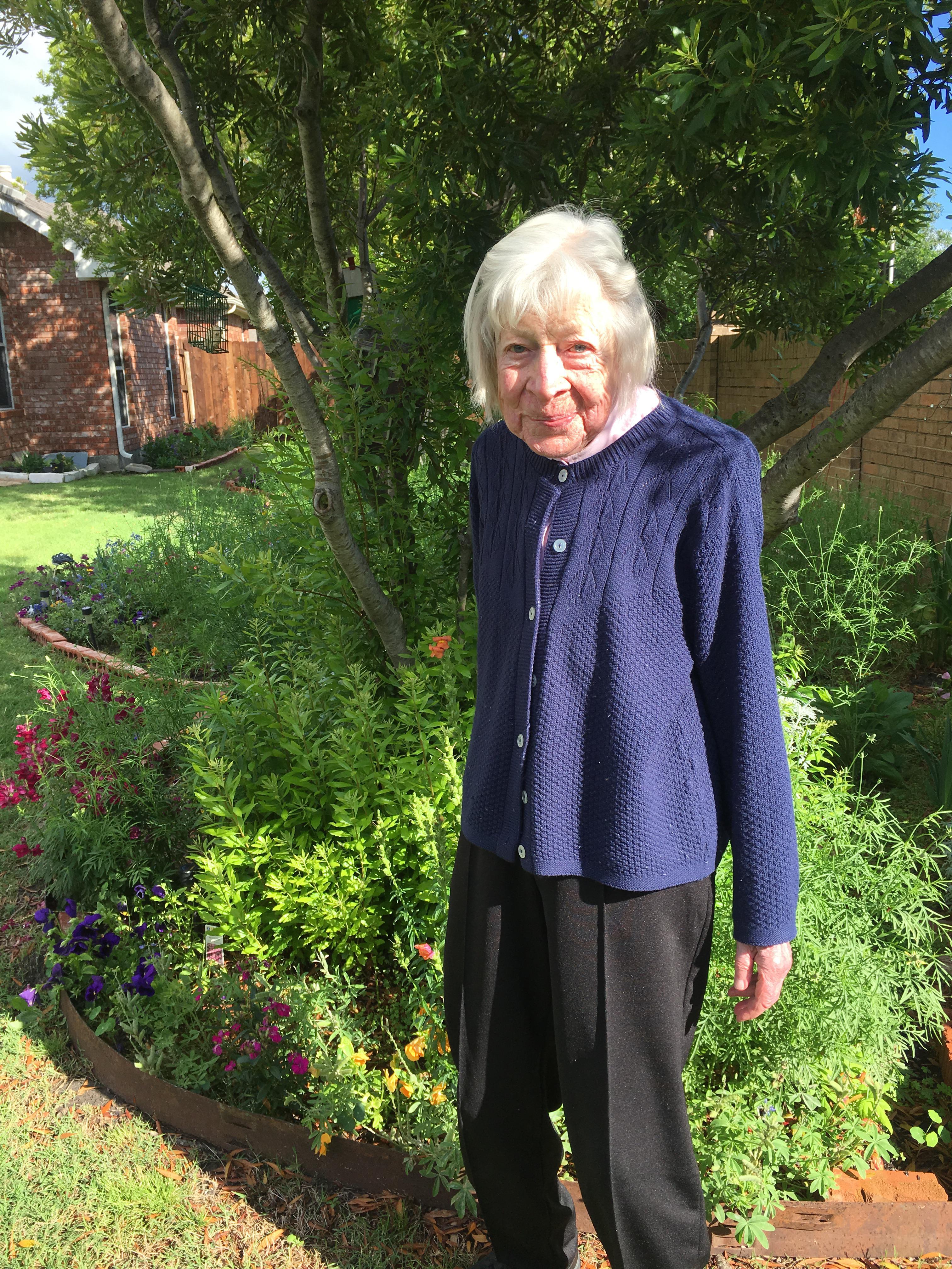 Evelyn enjoying beautiful spring blooms in her flower garden earlier this year.