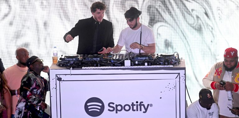 Jack Harlow and Zack Bia dancing and singing along to music at the DJ booth.