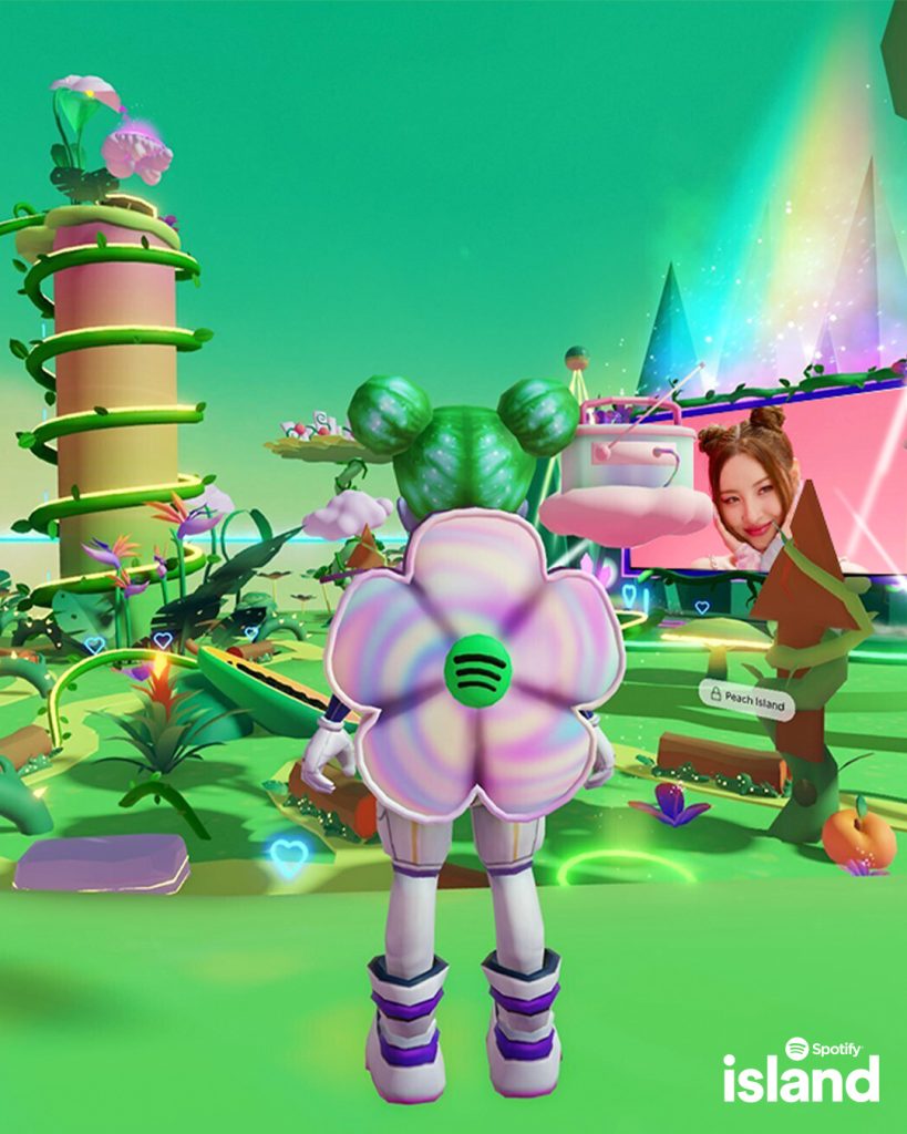 A player is watching the singer SUNMI on a giant screen on Spotify Island. The player is surrounded by bright green fauna.