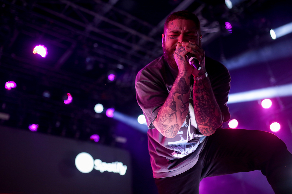 A singer performs onstage at a nighttime concert