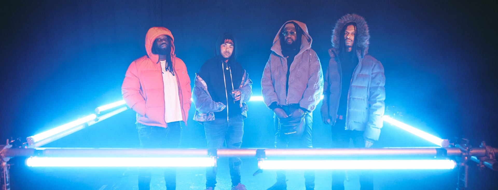 Wet Bed Gang standing within a square of neon light.