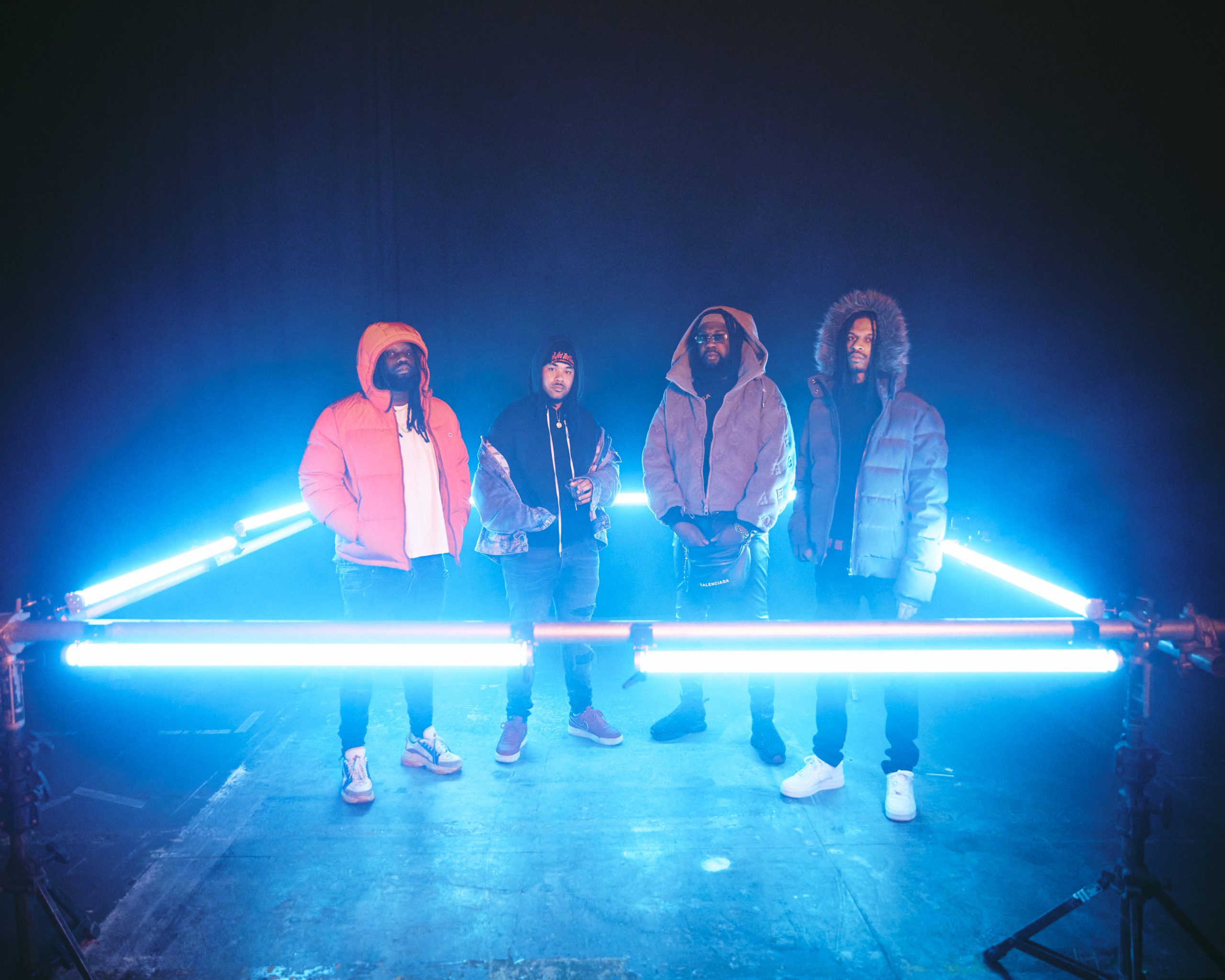 Wet Bed Gang standing within a square of neon light.