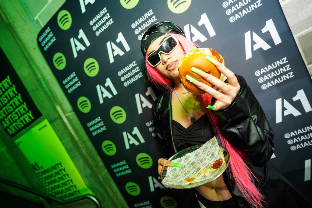 A.GIRL holding her sandwhich at Spotify x Butter event