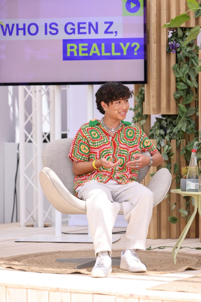 Thomas Pham sitting on an outdoor stage during a panel