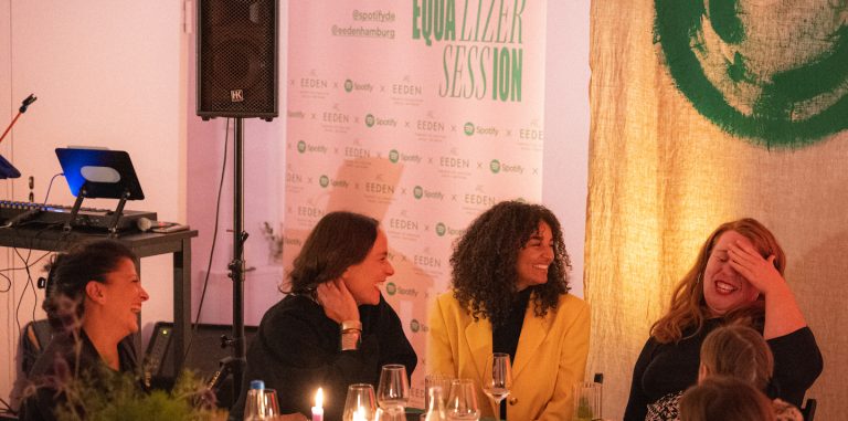 women sitting around a dinner table laughing at the spotify equalizer session. photo credit: swetlana holz