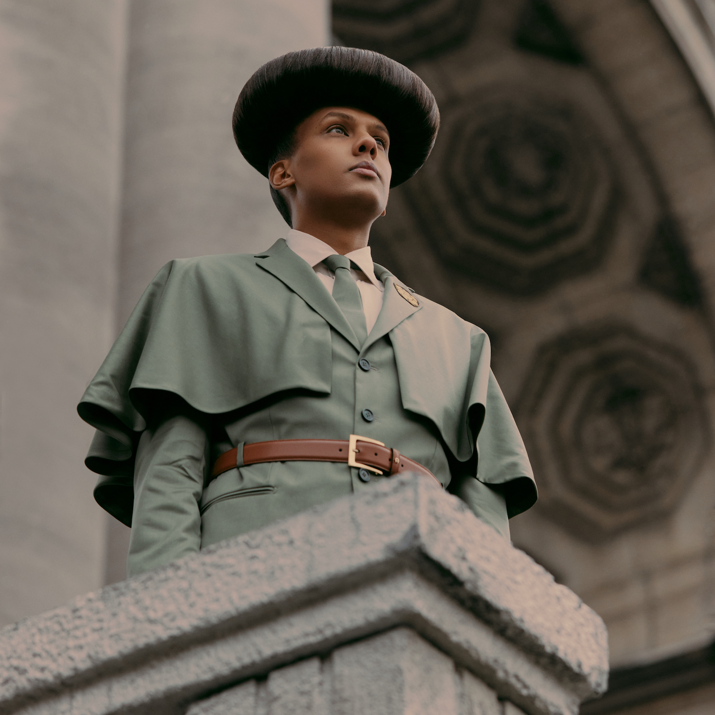 a photo of stromae standing on a platform looking out at a crowd