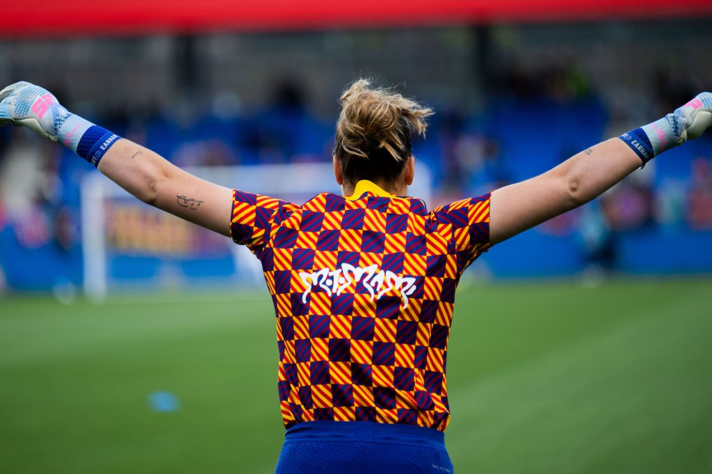 the goalie celebrates on the field with her arms in the air