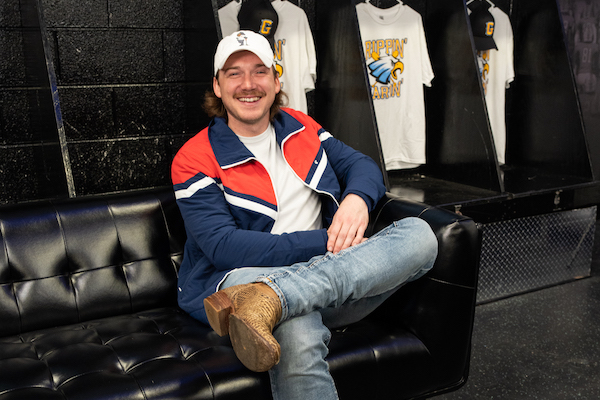 Morgan Wallen sitting on a couch in the baseball locker room at GHS