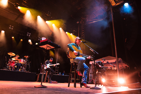 Morgan Wallen playing guitar and performing on stage