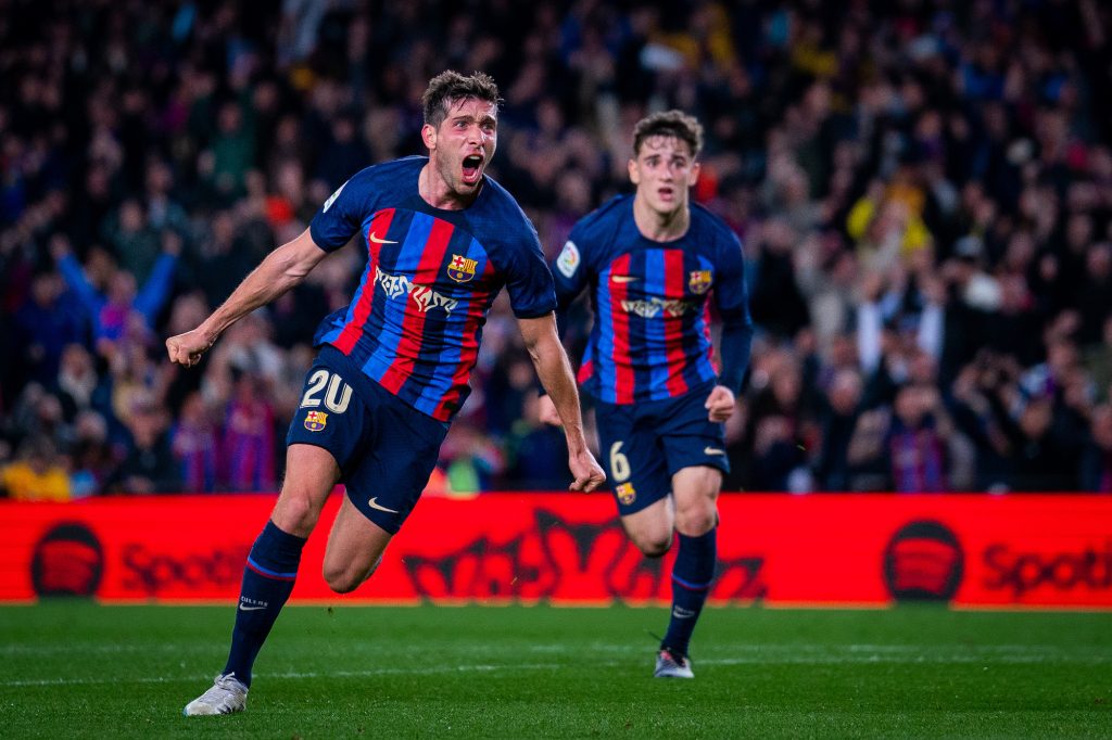 two fc barcelona players celebrating on field