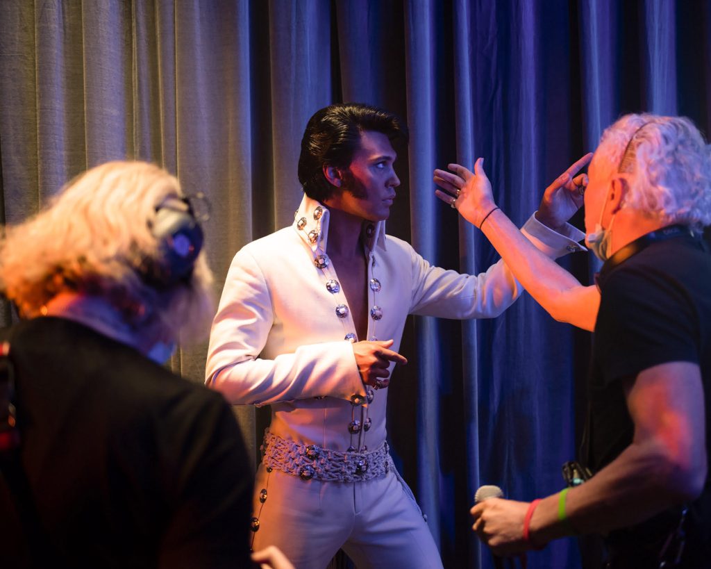 austin butler playing elvis and receiving direction on set from baz luhrmann