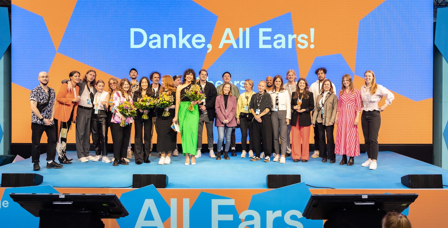 a group of participants standing on stage at the all ears summit