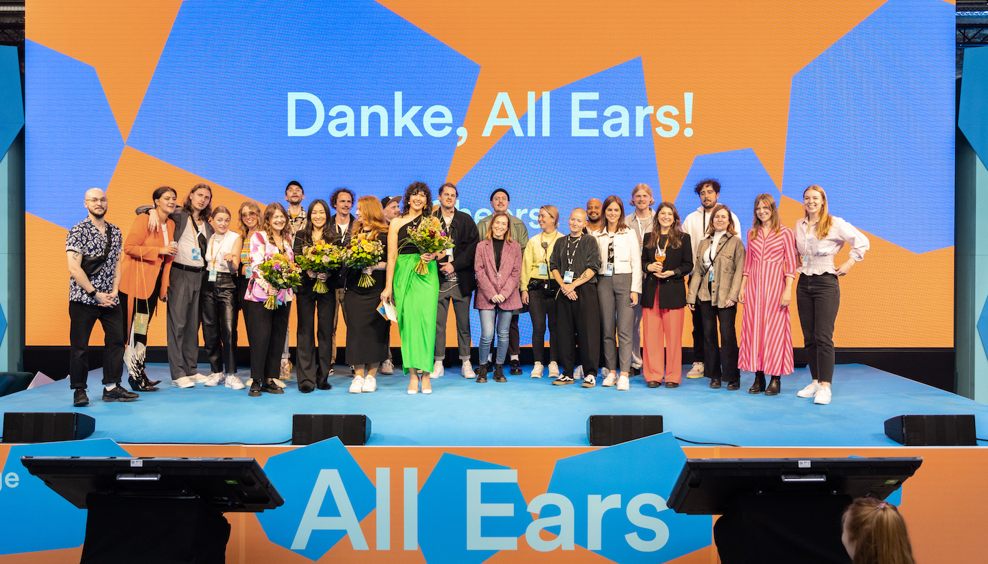 a group of participants standing on stage at the all ears summit