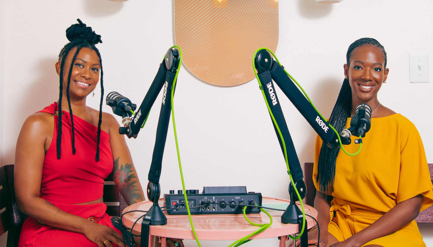 Quianah Upton and Jennifer Lind sitting in the new podcast studio in front of two mics at Nourish Botanica