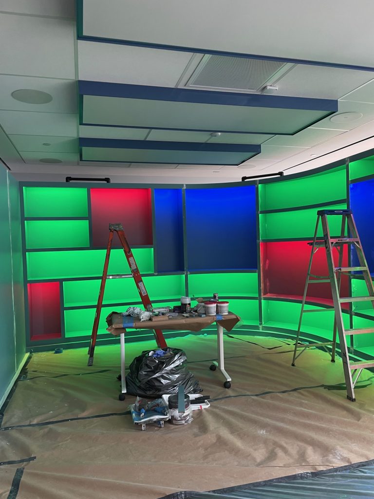 a colorful booksheld that is backlit with green, red, and blue lights