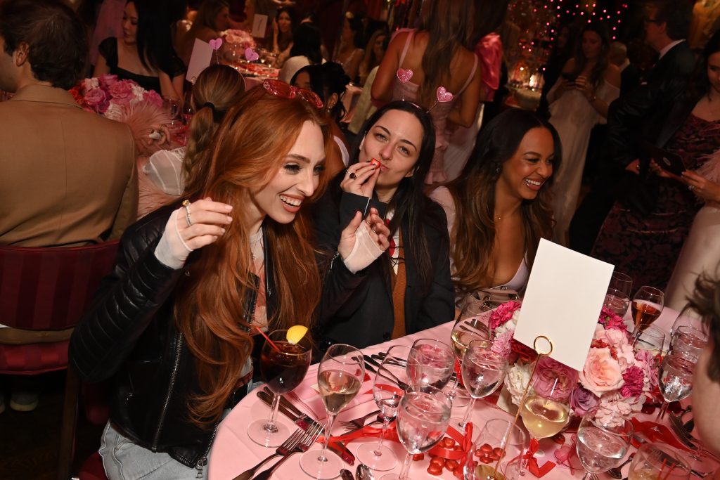 Women sitting at a table at a pink themed celebration