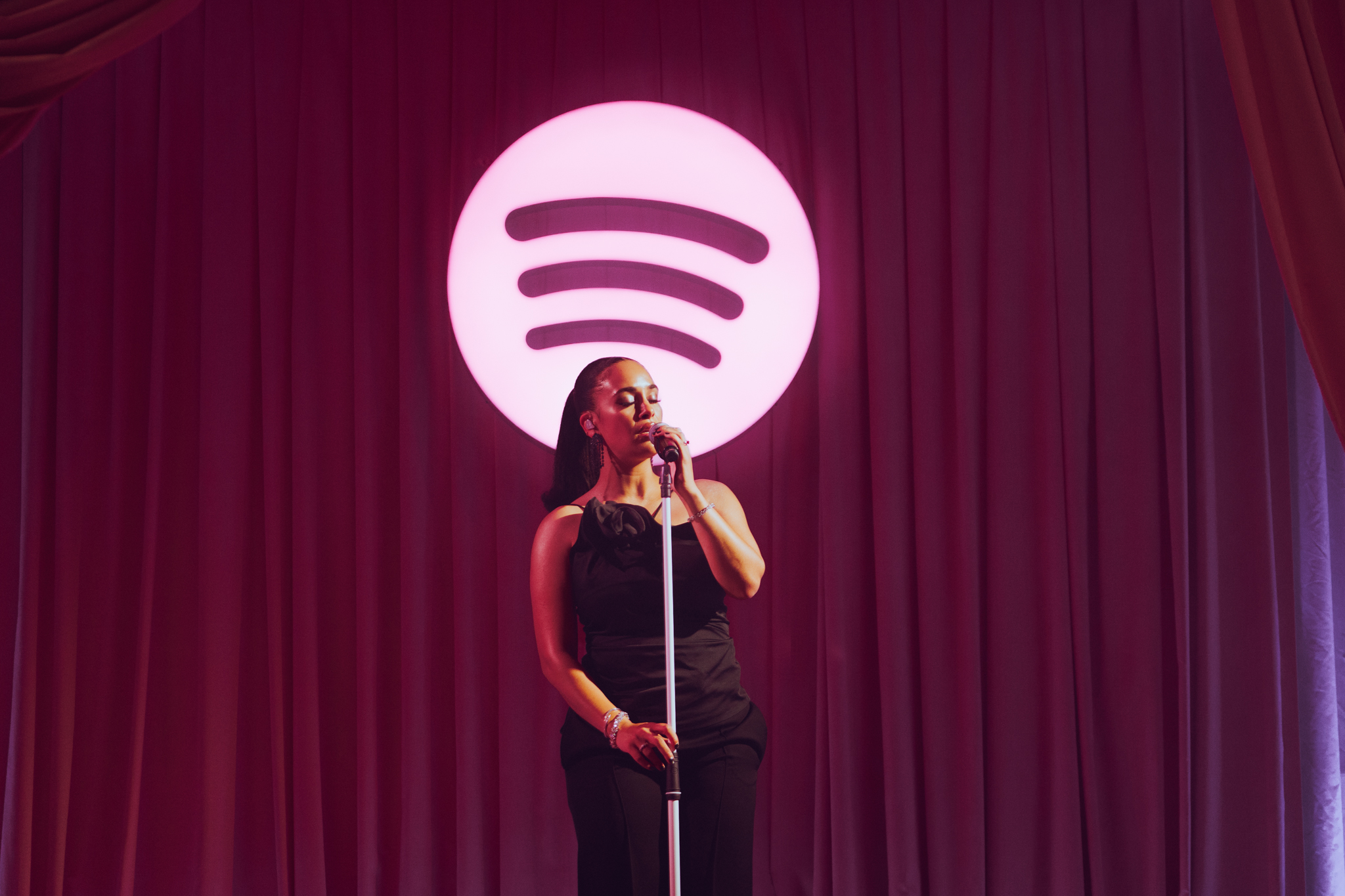 Jorja Smith performs in front of the Spotify logo