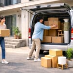 引っ越し作業でハイエースにダンボールを積みこむ人