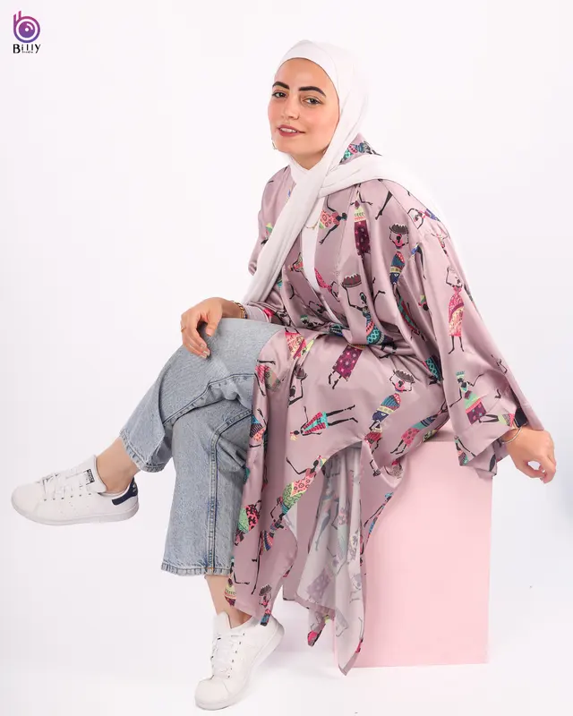 Layered outfit with a long printed mauve kimono worn over a white top and light-wash cropped jeans, white hijab and white trainers