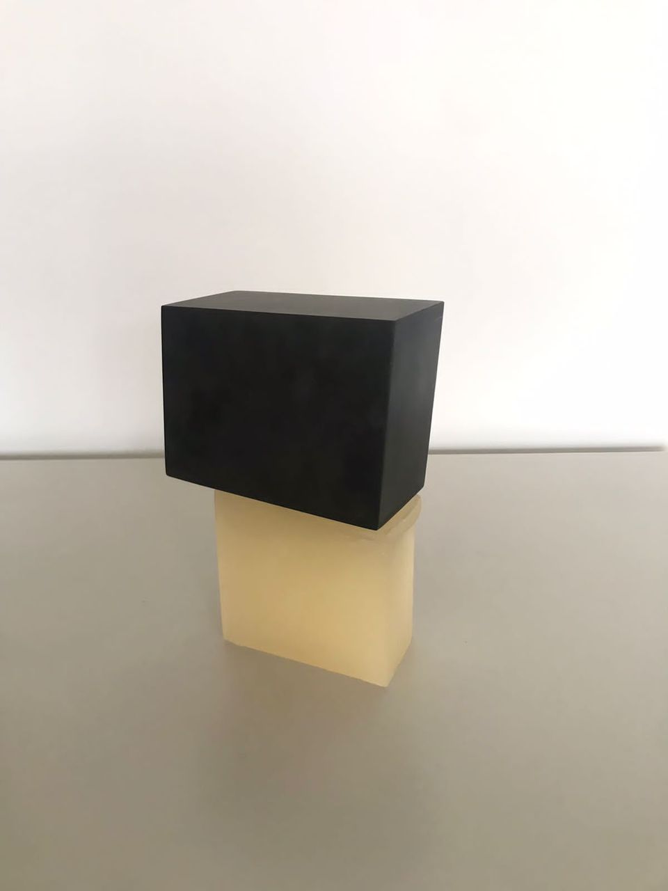 Estudo para uma coisa apoiada sobre outra , 2022 | Parafina e basalto 13 x 21 cm