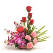 4 roses, 4 carnation, 6 orchid with teddy in a basket