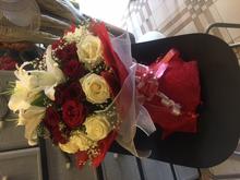 25 red and white roses and two lilly with paper packing