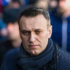 Alexei Navalny, pictured from the shoulders up, wearing a navy scarf and coat