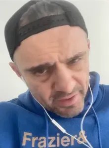 Still image from Gary Vee's video. He's wearing a blue sweatshirt and black baseball cap.