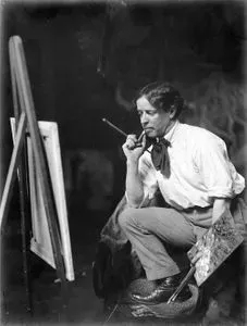 Black and white photograph of artist Charles Goldie standing at an easel