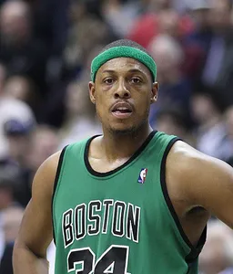 Paul Pierce, standing on the court wearing a green sweatband and a Celtics jersey