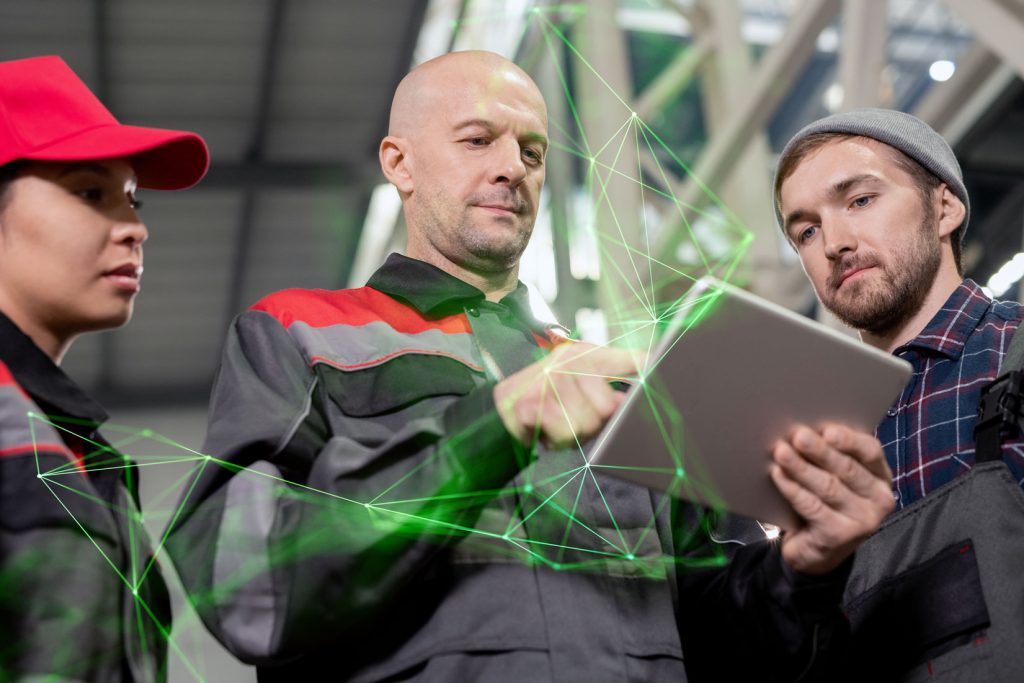 Fleet manager standing around colleagues showing them tablet with green plexus overlayed