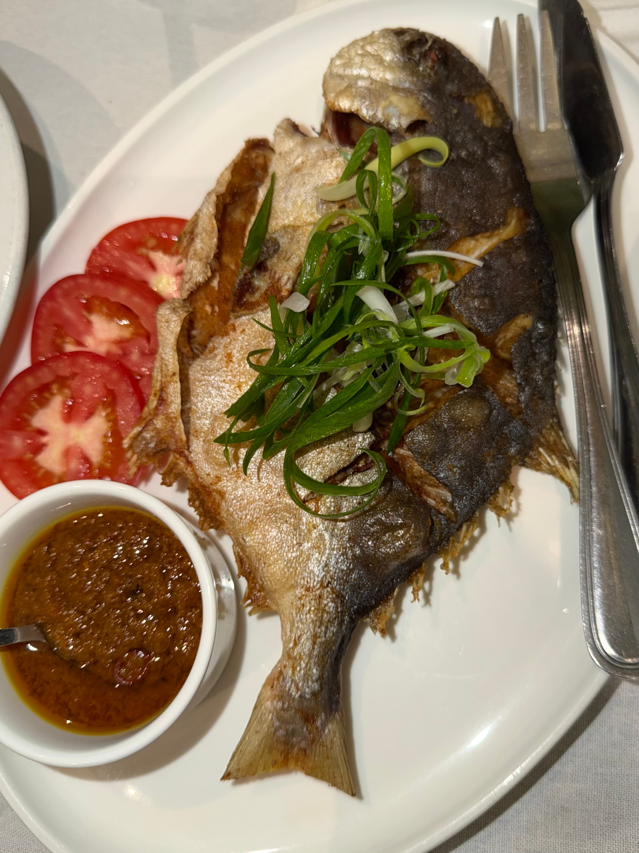 Fried Pompano, whole pompano fried until golden and crisp, highlighting the natural flavor of the fish with a satisfying crunch.