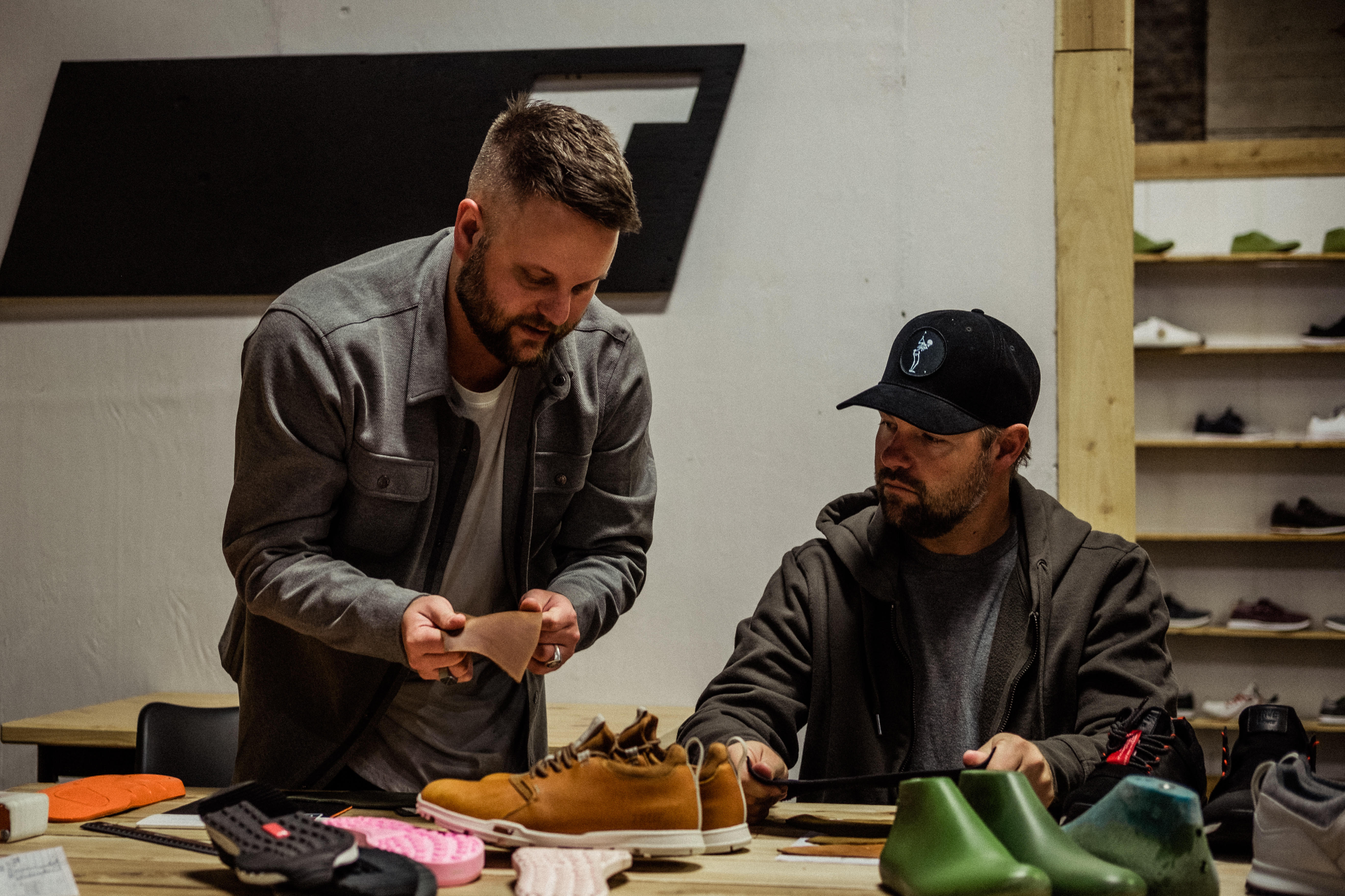 Two men confer while designing golf footwear.