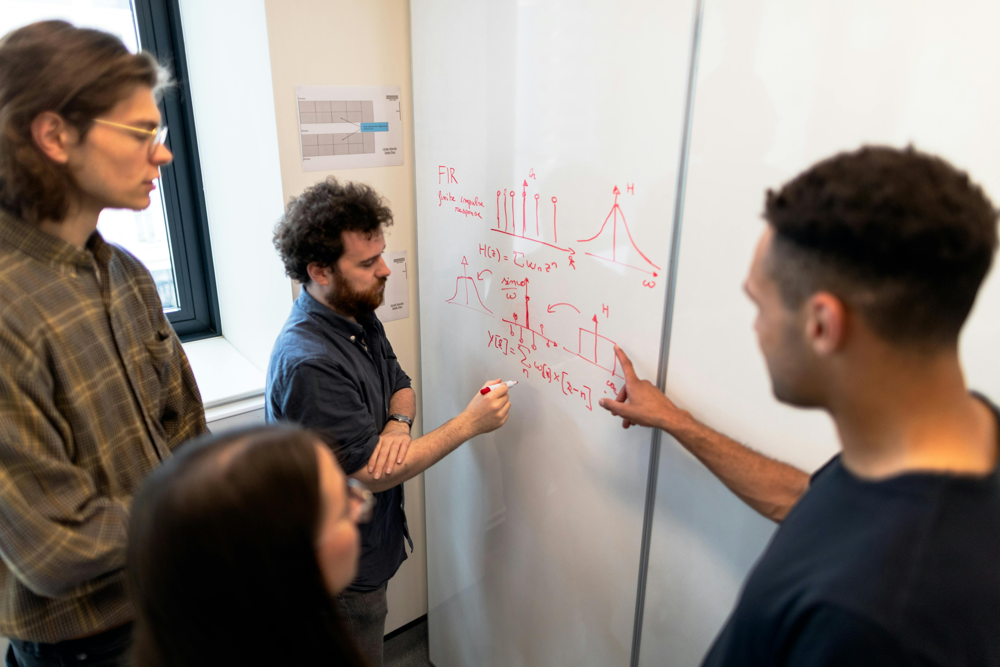 Data science projects often involve collaborative brainstorming. In modern workplaces, teams of data scientists and ML engineers work together on whiteboards and code to solve complex problems.