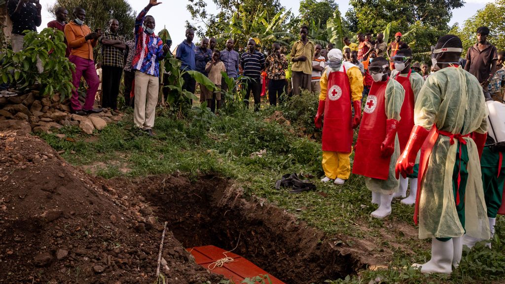 A prayer is read during a Safe and Dignified Burial of an Ebola victim on October 11, 2022 in Mubende, Uganda. Emergency response teams, isolation centres and treatment tents have been set up by the Ugandan health authorities around the central Mubende district after 17 recorded deaths and 48 confirmed cases from an outbreak of the Ebola virus. The first death from this outbreak of the Ebola-Sudan strain of the virus was announced on 19 September and as yet, there is no vaccine for this strain. LUKE DRAY VIA GETTY IMAGES 