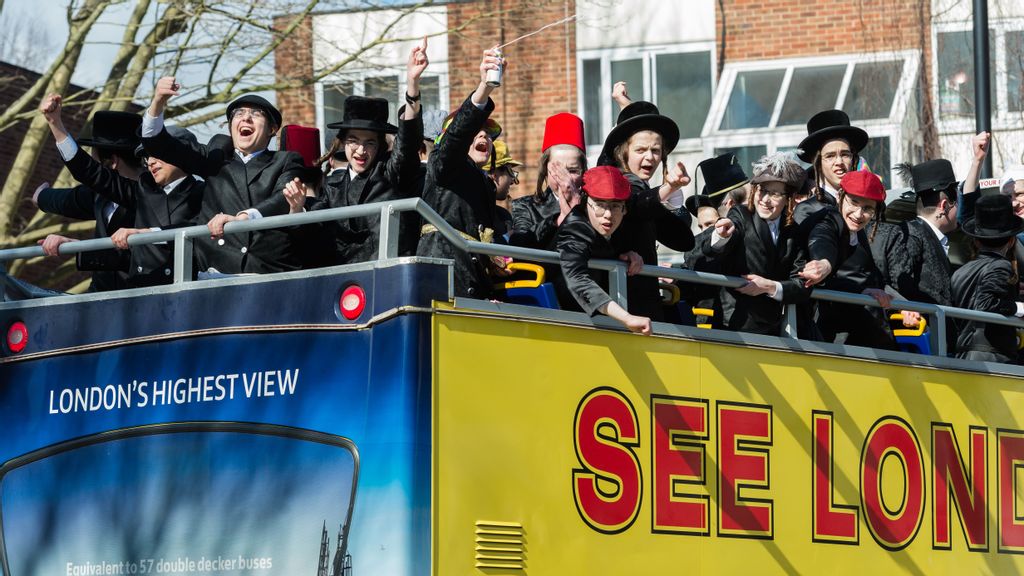 Orthodox Jewish men on double-decker bus celebrate the annual holiday of Purim on the streets of Stamford Hill in London, United Kingdom on March 17, 2022. PHOTO BY WIKTOR SZYMANOWICZ/ANADOLU AGENCY VIA GETTY IMAGES