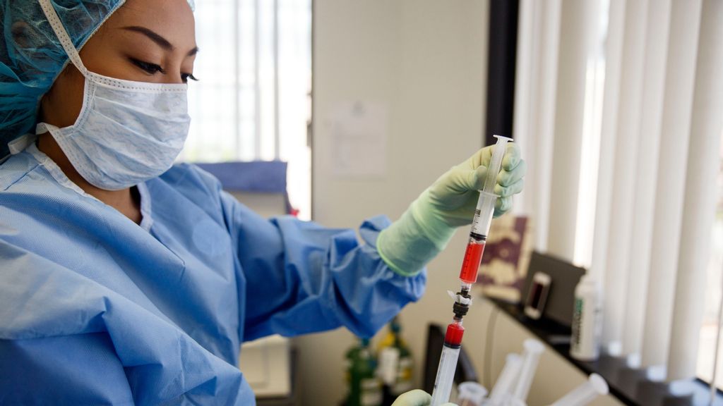 Assistant Audrey Fianza transfers between two syringes cells retrieved for stem cell therapies from a patient after being spun in the Time Machine centrifuge in the office of Dr. Mark Berman on Tuesday, August 16, 2016 in Beverly Hills, CA. (Photo by Patrick T. Fallon for The Washington Post via Getty Images)