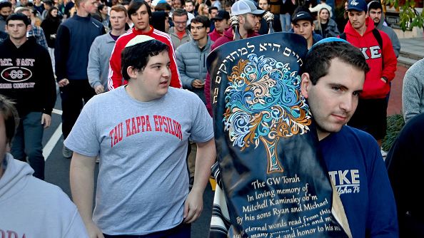 Members of the Jewish fraternity Tau Kappa Epsilon at George Washington University walk with a new Torah that was donated to the fraternity in Washington, D.C. on November 1, 2021. Anti-Semitic incidents are believed to have increased on campus. MICHAEL S. WILLAIMSON/THE WASHINGTON POST VIA GETTY IMAGES 