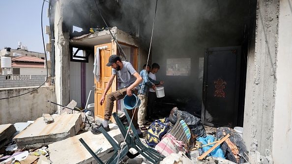 Palestinians fight the fire inside a building following clashes between Israeli forces and Palestinians in Nablus, Palestine, on August 30, 2022. Palestinians opened fire at Israeli Jews who were headed to Joseph's Tomb. JAAFAR ASHTIYEH/AFP VIA GETTY IMAGES