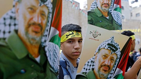 Palestinian Fatah movement supporters gather during a rally on the 18th anniversary of Yasser Arafat's death in the West Bank city of Nablus on November 14, 2022. The head of the probe into his murder says he is being silenced. ZAIN JAAFAR/AFP VIA GETTY IMAGES