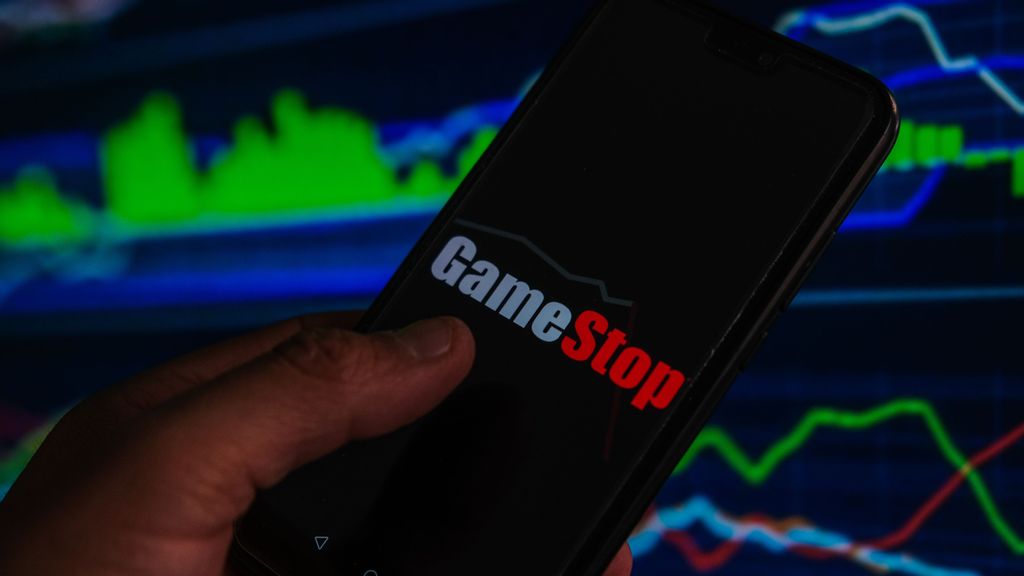 In this photo illustration a GameStop logo is displayed on a smartphone with stock market percentages in the background. GameStop was considered the biggest headline in the financial market in 2021. OMAR MARQUES/BENZINGA