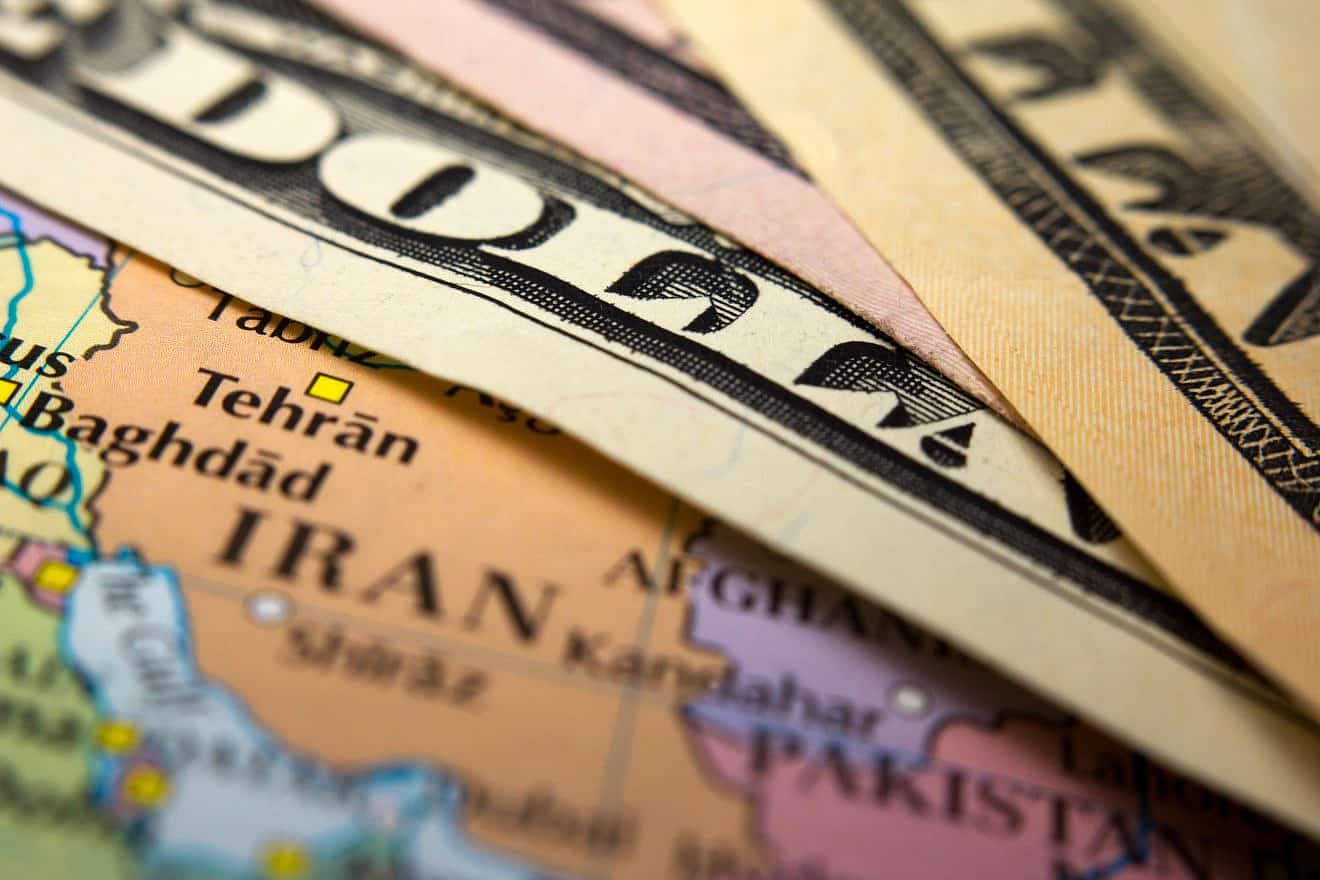 <p>Dollar bills on top of a map of Iran. The United States has reached a quiet understanding with Qatar to put a hold on the scheduled transfer of $6 billion to Iran. CORLAFFRA/SHUTTERSTOCK.</p>