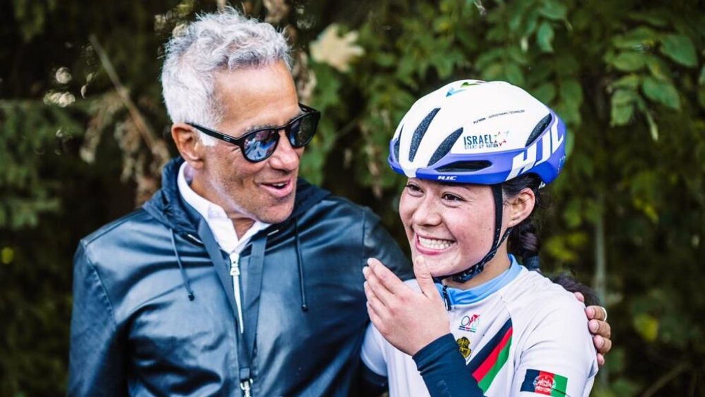 Sylvan Adams, left, congratulates Fariba Hashimi, a contestant in the Afghan national cycling championship held in exile in Switzerland. She says she is racing for all the women in her country. NOA ARNON 