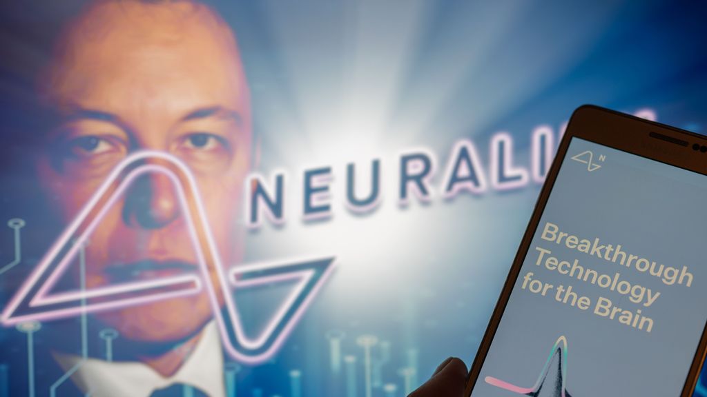 Neuralink logo displayed on mobil with founder Elon Musk seen on screen in the background. Neuralink Corporation is a neurotechnology company that develops implantable brain-computer interfaces. In Brussels on 4 December 2022. JONATHAN RAA/BENZINGA
