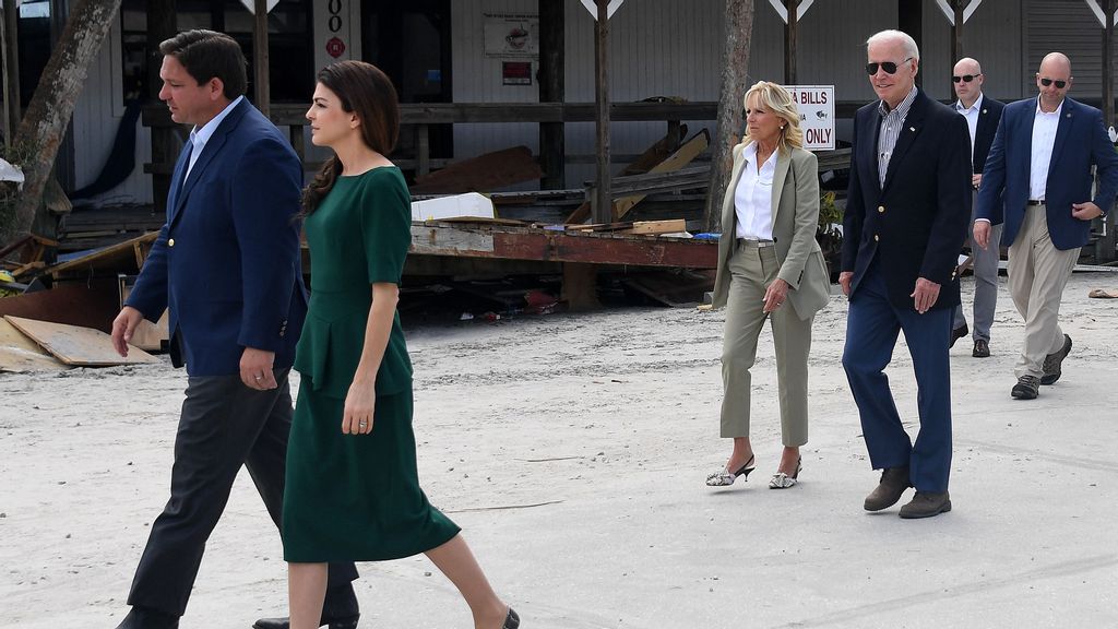 Florida Governor Ron DeSantis (L) and his wife Casey walk ahead of US President Joe Biden and First Lady Jill Biden through a neighborhood impacted by Hurricane Ian at Fishermans Pass in Fort Myers, Florida, on October 5, 2022. OLIVIER DOULIERY/BENZINGA