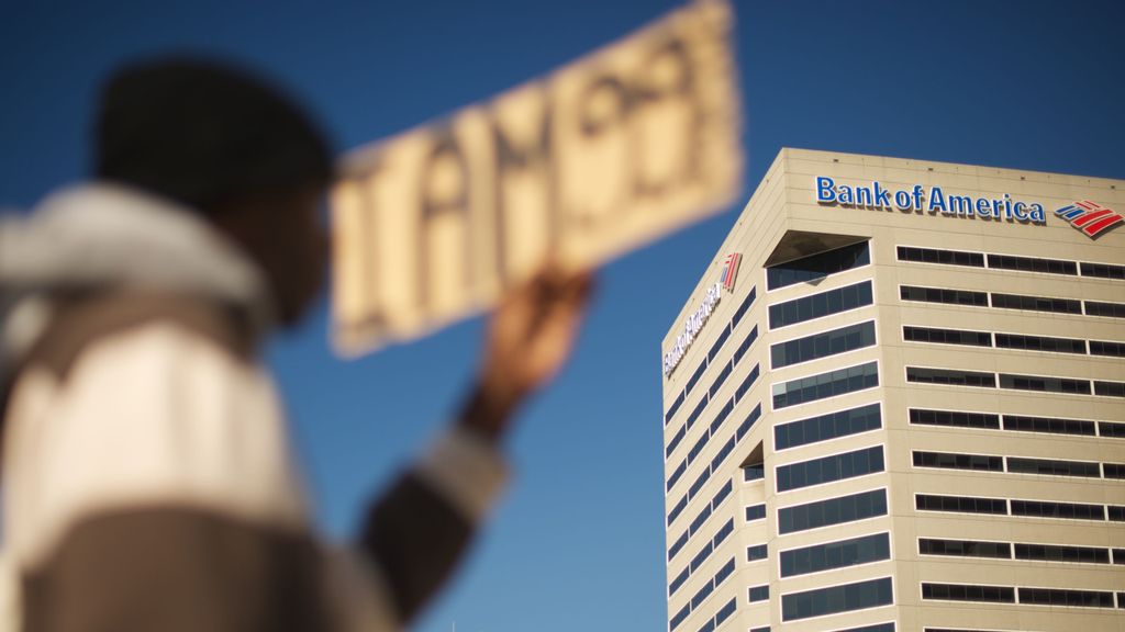       In view of the Bank of America building in Baltimore, MD, a man participates in Occupy Baltimore October 7, 2011, supporting the Wall Street protestors who are against corporate greed, the continued divide between rich and poor to name a few. (KEN CEDENO/GETTY IMAGES) 