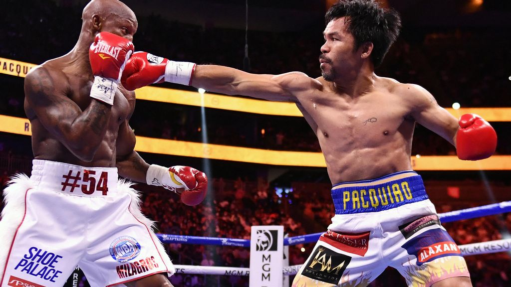 <p>Manny Pacquiao (R) throws punch at Yordenis Ugas during their WBA welterweight title fight at T-Mobile Arena in Las Vegas, Nevada. Manny Pacquiao recieves shock disqualification from Olympic organizers. ETHAN MILLER/GETTY IMAGES. </p>