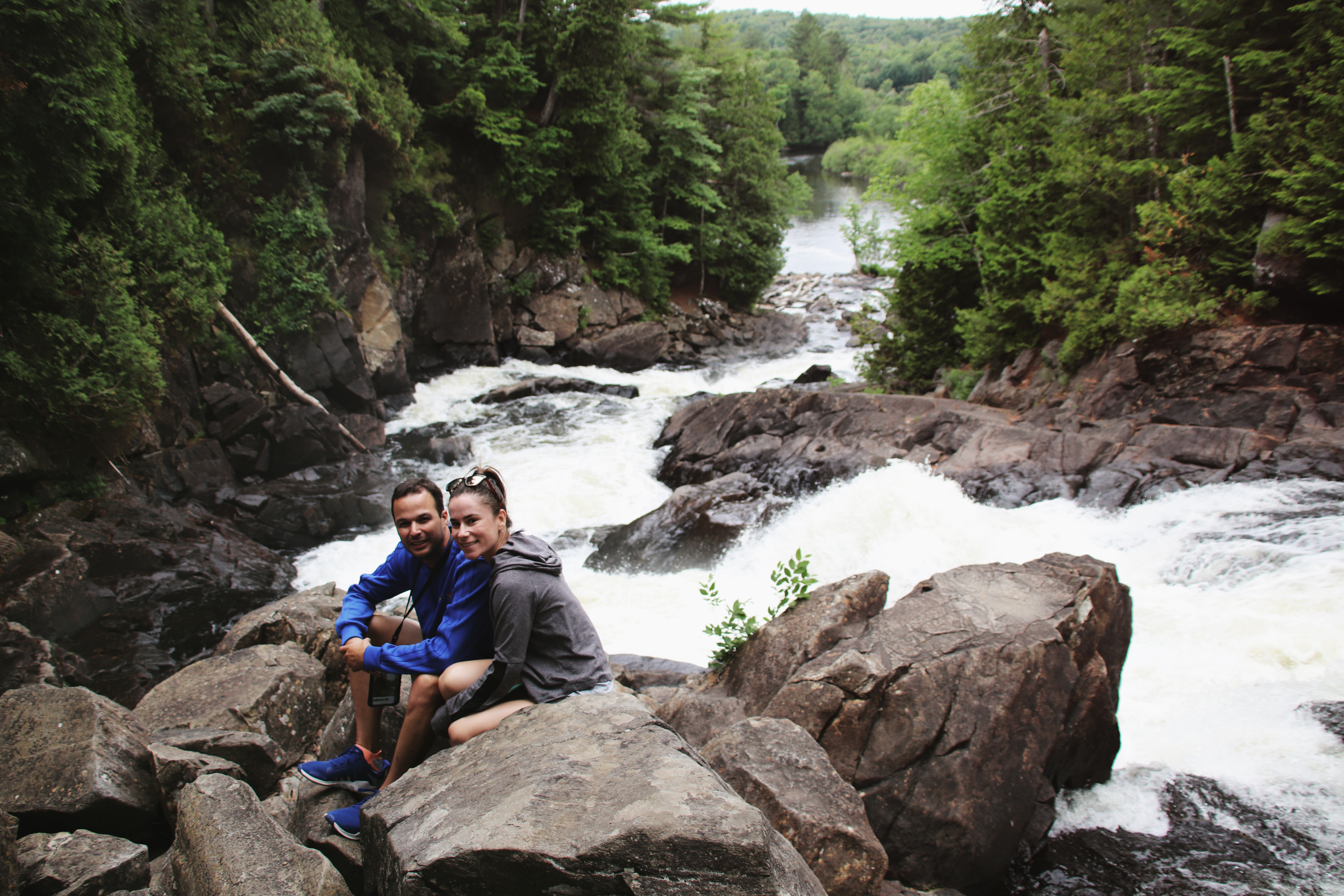 Couple sitting at Ragged Falls on the rock