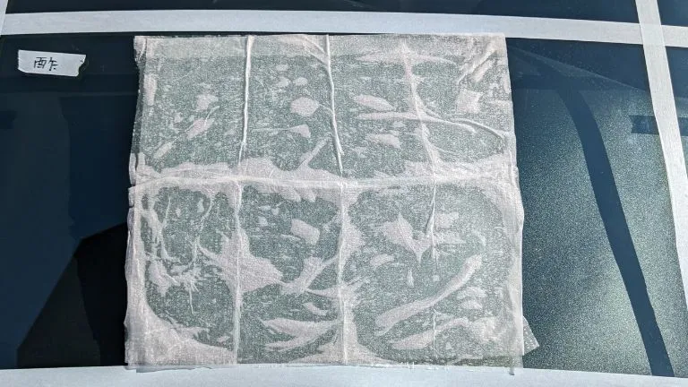 車のフロントガラスに付着した水垢をお酢で除去している画像です。